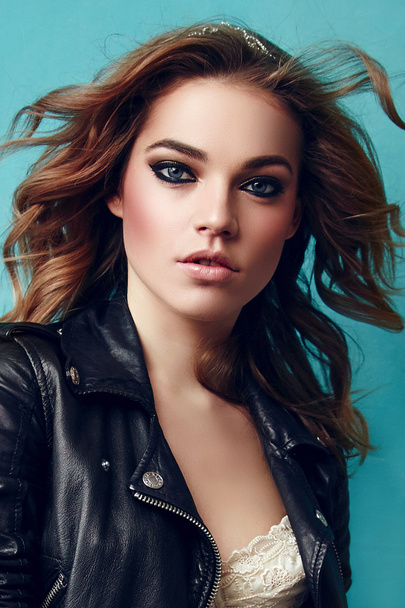 Fashionable girl in a leather jacket with developing hair in the wind. - Foto, immagini