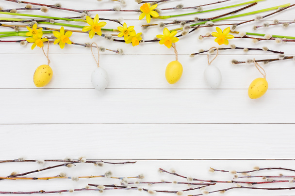 Easter background with decorative Easter eggs, narcissus  and willow tree branch. Copy space - Photo, Image