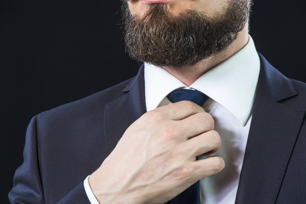 Elegant man correcting his necktie. - Foto, Imagen
