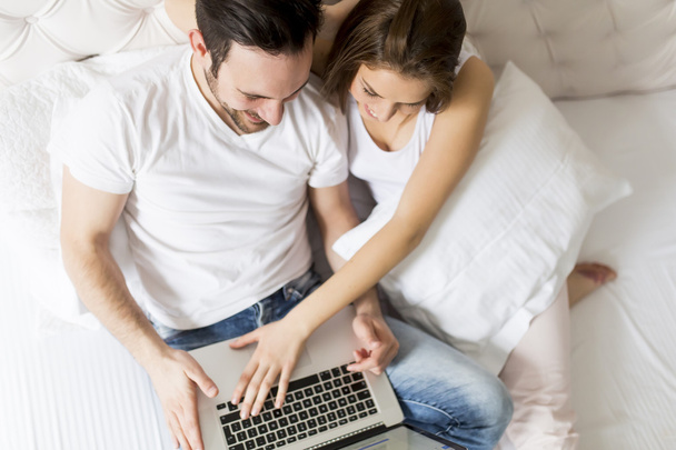 Пара с ноутбуком в кровати
 - Фото, изображение