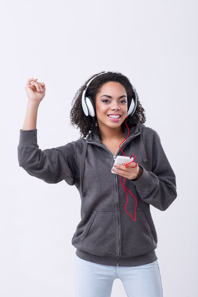 Positive mulatto woman listening to music - Photo, Image