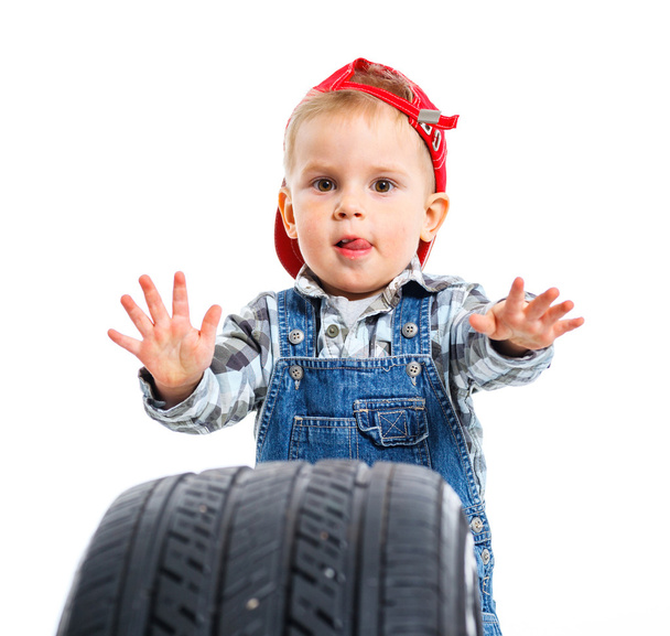 Little mechanic with a tire - Foto, afbeelding