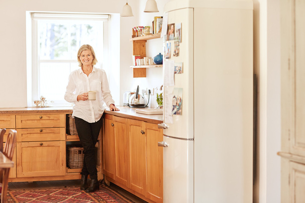 senior woman in bright and tidy kitchen - Fotoğraf, Görsel