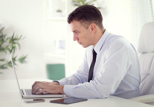 Businessman working on laptop in office - Foto, imagen