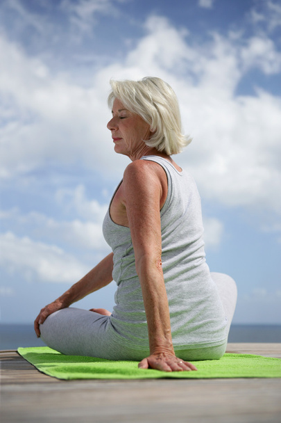 Middle-aged woman doing yoga outdoors - Zdjęcie, obraz