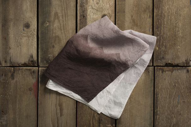 Folded Gradient Brown Cloth or Linen on Wooden Panel Surface - Photo, Image