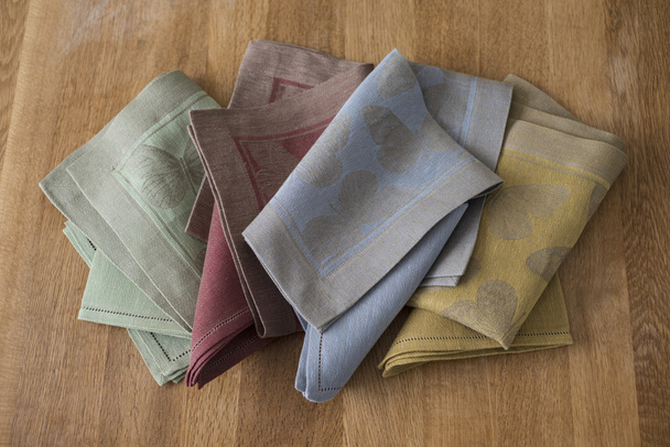 Manteles plegables y servilletas de varios colores en la superficie de madera
 - Foto, Imagen