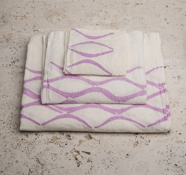 Stapel handdoeken met paarse concaaf lijnen onder hoge hoek - Foto, afbeelding