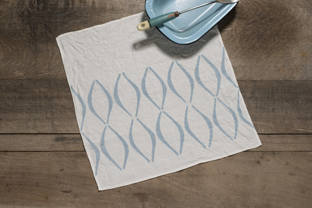 Square Table Napkin with Blue Concave Lines Alongside Blue Tray - Photo, Image