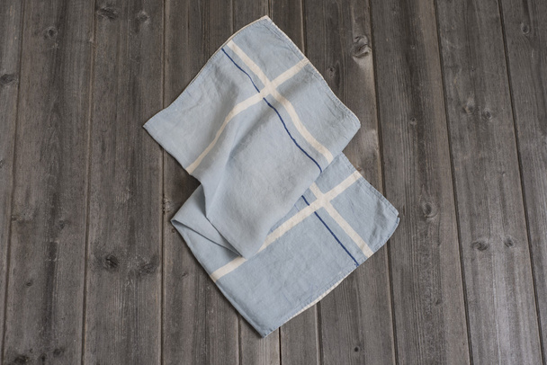 Полотенце из голубой ткани с белыми и темно-голубыми полосами пересечения
 - Фото, изображение