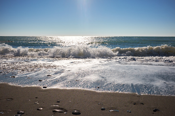 Waves wash over dark sand - Фото, изображение