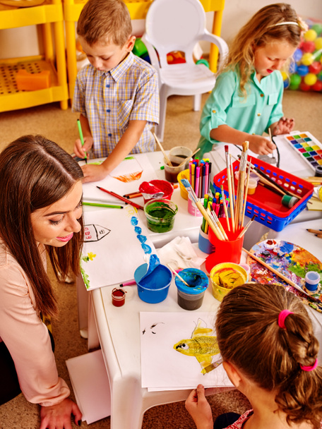 Crianças com professor mulher pintura no papel no jardim de infância
 . - Foto, Imagem