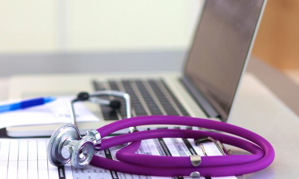 A medical stethoscope near a laptop on a wooden table, on white - Photo, Image