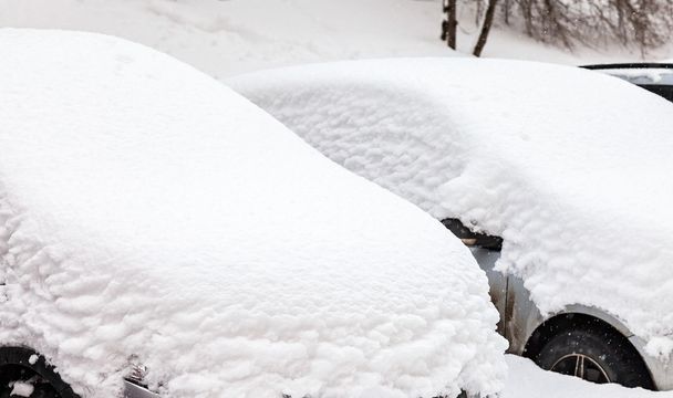 車が駐車場に冬の吹雪で雪で覆われました。 - 写真・画像