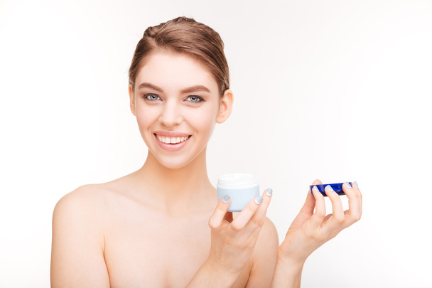 Smiling cute woman holding facial cream - 写真・画像