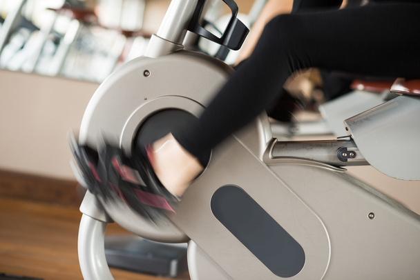 Woman working out on stationary bike - 写真・画像