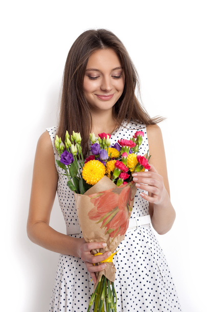 Young cute woman holding bunch of flowers - Фото, изображение