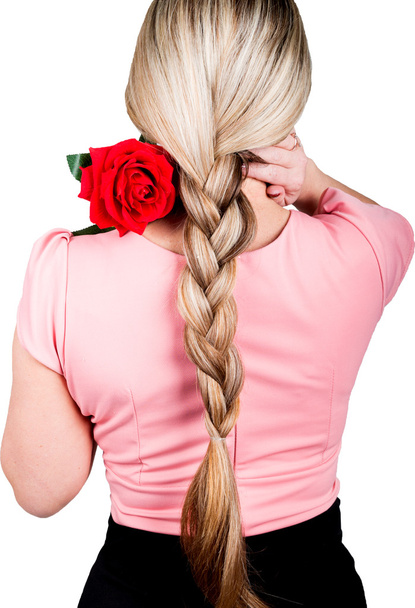chica en una blusa rosa, su pelo trenzado. en el hombro de una rosa roja. Vista trasera. aislado sobre fondo blanco
 - Foto, Imagen