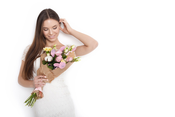 Young cute woman holding bunch of flowers - Photo, image