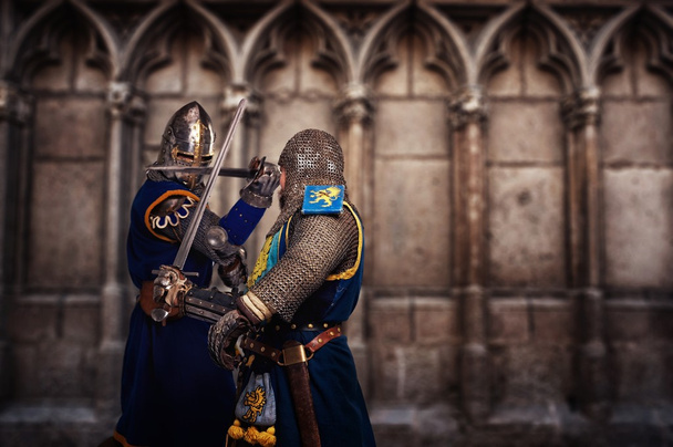 Deux chevaliers combattant agaist mur de cathédrale médiéval
 - Photo, image