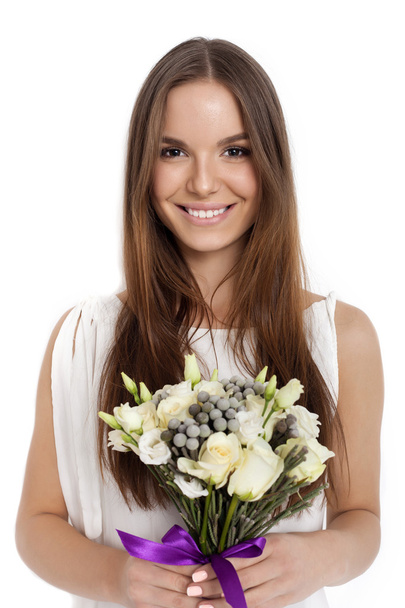 Pretty beautiful girl holding bunch of flowers - Фото, изображение