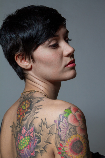 Gros plan d'un tatouage d'une femme brune aux cheveux courts
 - Photo, image