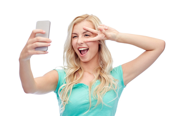 smiling young woman taking selfie with smartphone - Valokuva, kuva