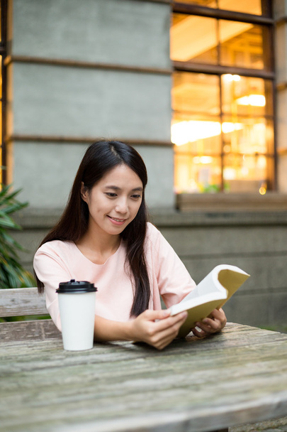 Mujer leyendo en libro en la cafetería al aire libre
 - Foto, Imagen
