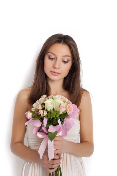 Young cute woman holding bunch of flowers - Foto, afbeelding