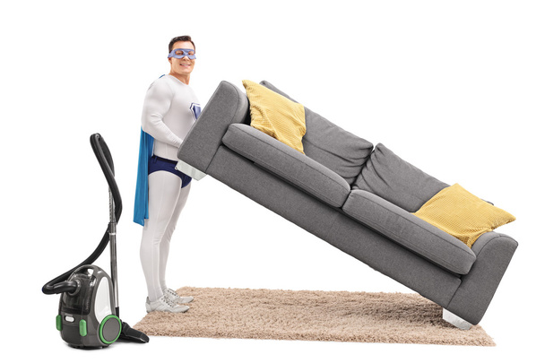 Superhero lifting a sofa and vacuuming - Foto, Imagem