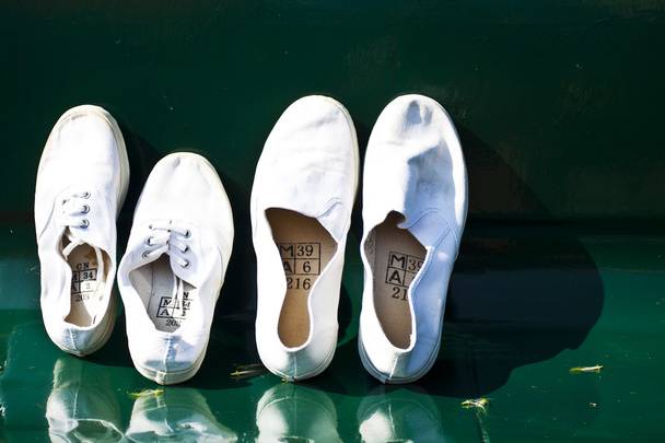 Pari valkoisia kenkiä tuolilla
 - Valokuva, kuva