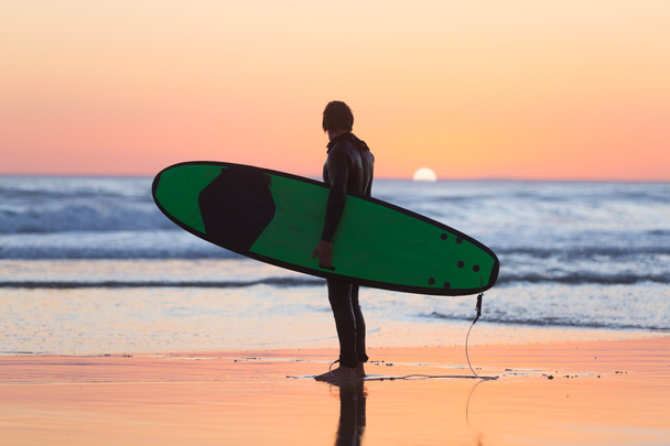 Silhouette de surfeur sur la plage avec planche de surf
. - Photo, image