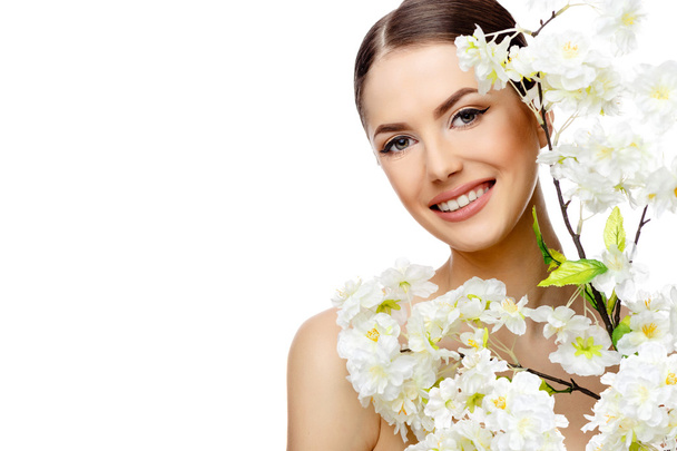 Beautiful Woman with Clean Fresh Skin holding flowering branches - Фото, зображення