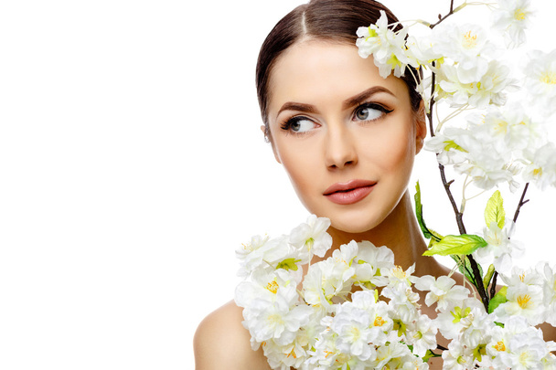 Beautiful Woman with Clean Fresh Skin holding flowering branches - Фото, изображение