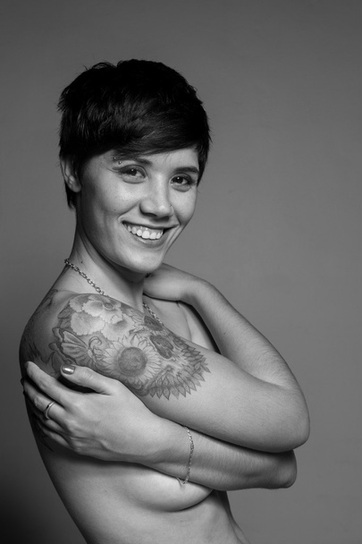 Naked short-hair brunette woman covering her breasts with her ar - Valokuva, kuva