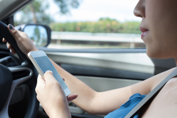 nainen kuljettaja käyttää älypuhelinta autossa
 - Valokuva, kuva