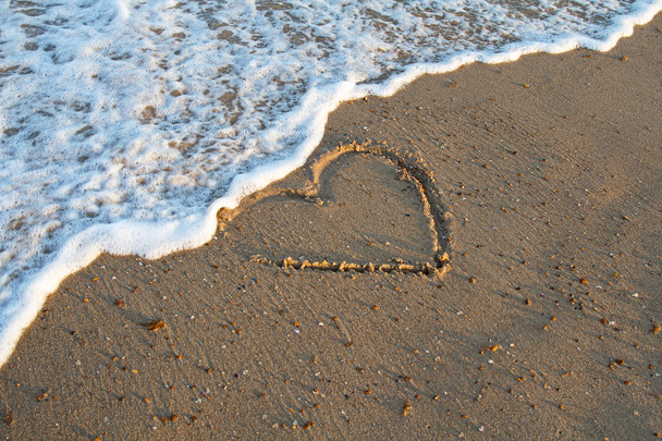 Καρδιά χειρόγραφη σε ένα αμμουδιά της παραλίας με κύμα. Φόντο - Φωτογραφία, εικόνα