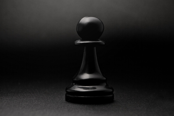 Chess. Black pawn on a black background. Pawn, infantry chess. - Fotografie, Obrázek