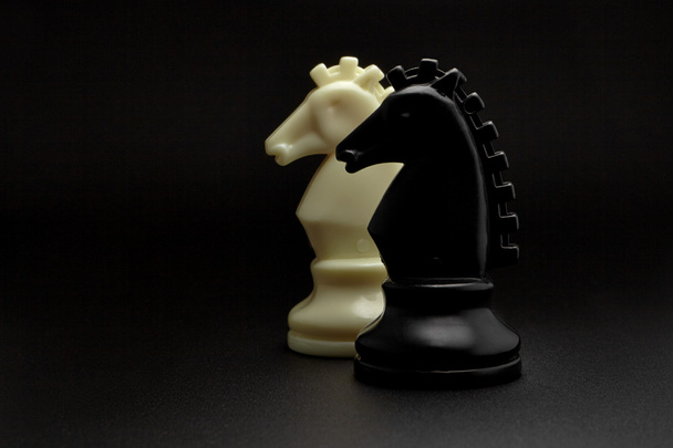 Chess. Black and White Knights on black background. Set of chess figures. Chess Horses. - Φωτογραφία, εικόνα