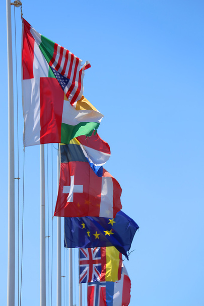muitas bandeiras de muitas nações no vento com céu azul
 - Foto, Imagem