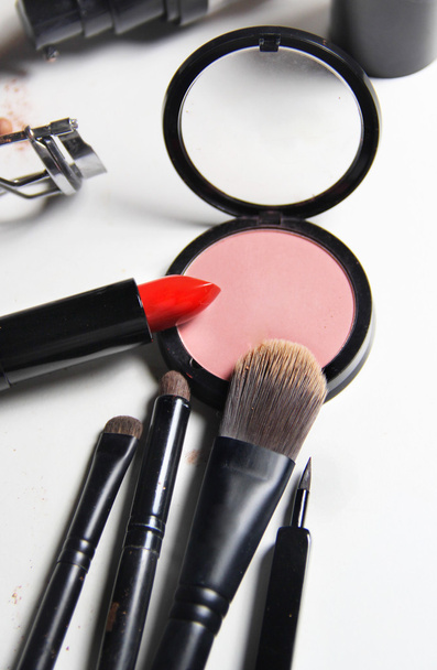 Rode lippenstift en mix van make-up borstels - Foto, afbeelding