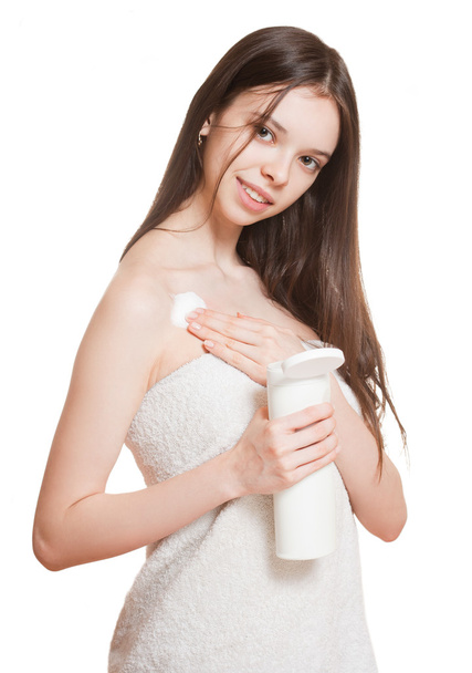 Young brunette using body lotion. - Фото, изображение