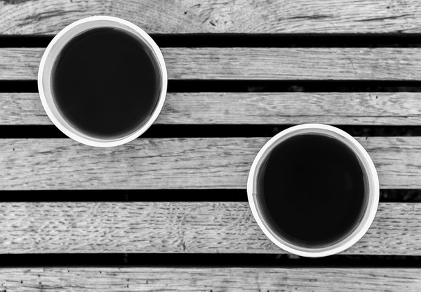Пара чашек чая на деревянной поверхности черно-белый
 - Фото, изображение