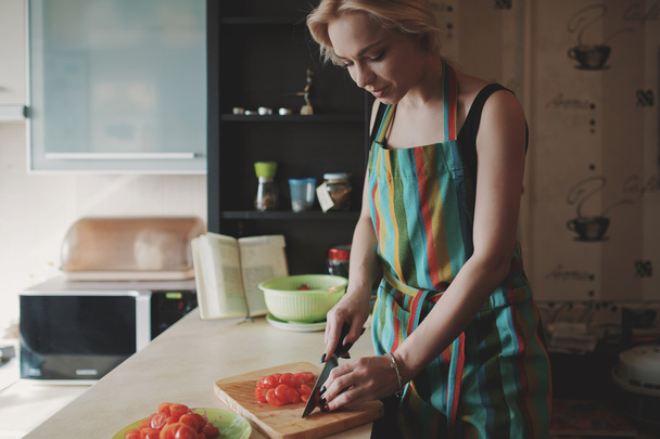 Jovem mulher cortando tomates
 - Foto, Imagem