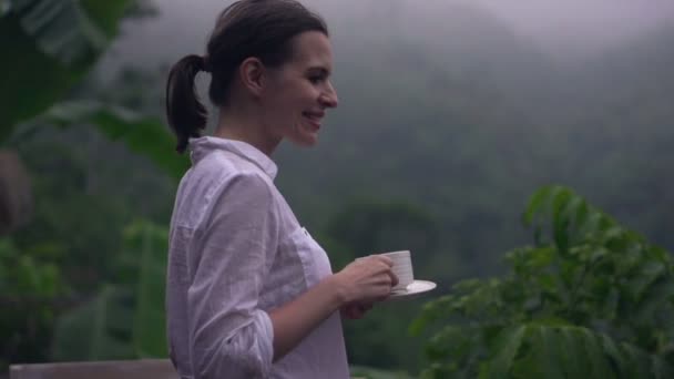 woman drinking coffee on terrace in evening - Felvétel, videó