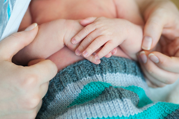 μητέρα χέρια κρατώντας μικρά όπλα νεογέννητο γιο - Φωτογραφία, εικόνα