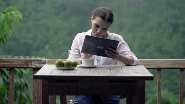 woman using tablet computer on terrace - Materiaali, video