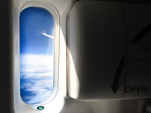 Patrząc przez okno okna wyjścia awaryjnego samolotu - Zdjęcie, obraz