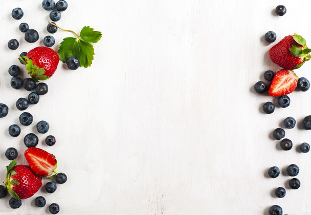 Fresh strawberries and blueberries on wooden background - Foto, Bild