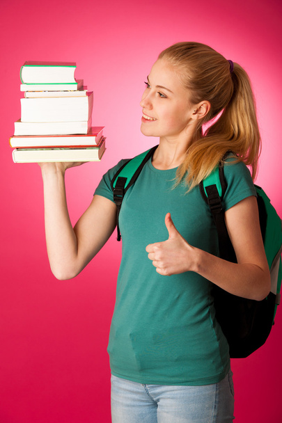 Blonde student with stack of books and backpack, happy to get kn - Zdjęcie, obraz